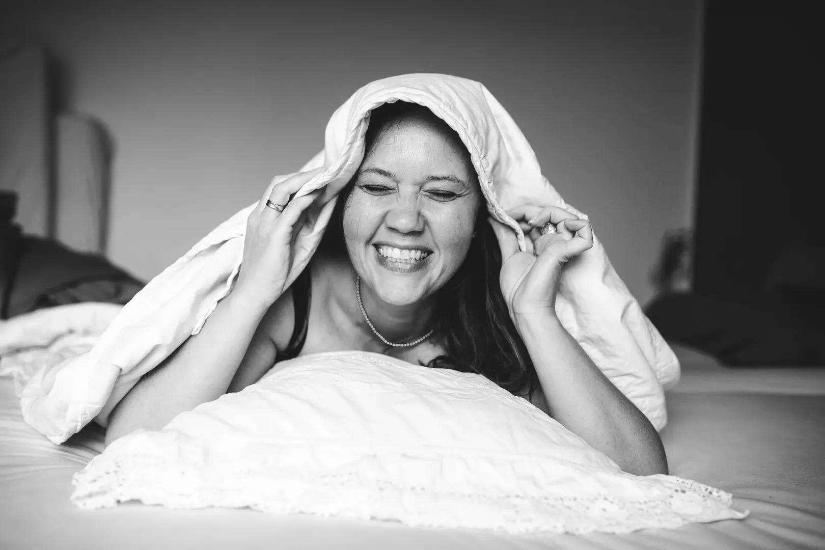 Frau glücklich unter der Bettdecke — erholsamer Schlaf